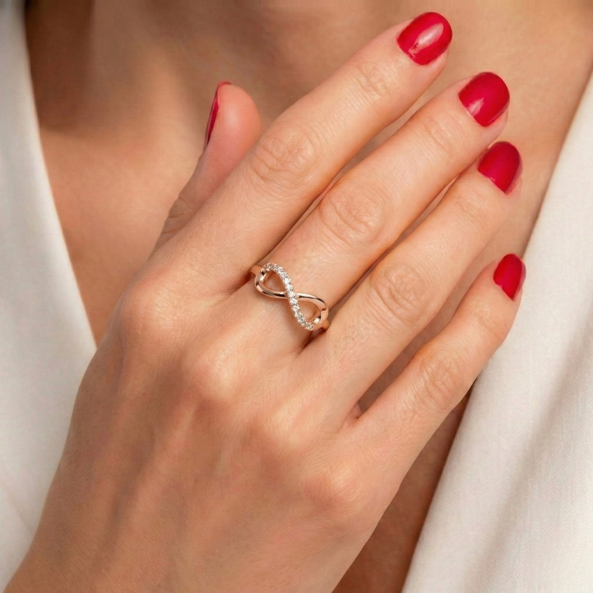 Bague Mémoire Infinie urne rose portée à la main, bijou discret symbole de lien éternel