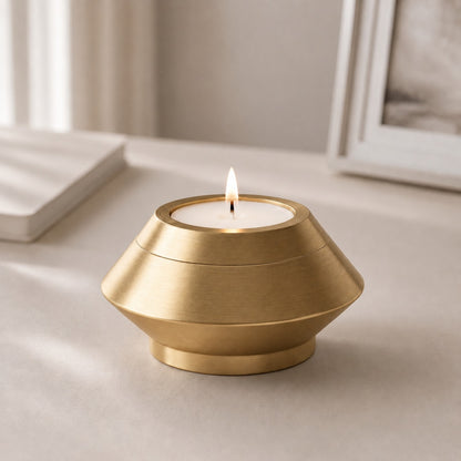 Bougie souvenir doré en acier inoxydable dans une ambiance intérieure élégante et apaisante