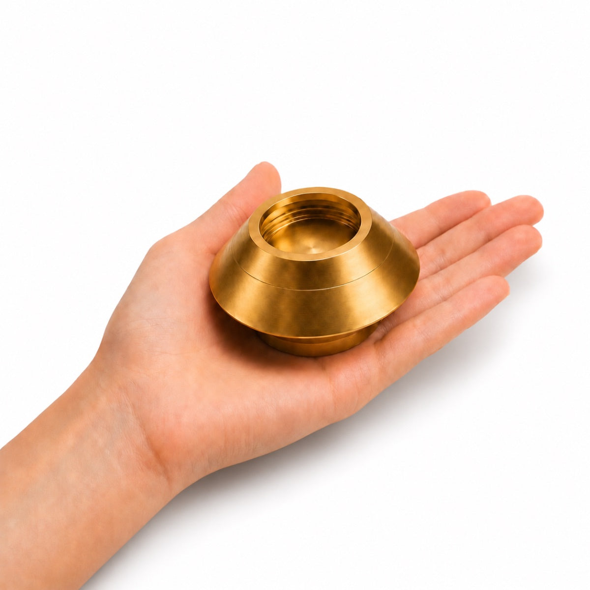Bougie souvenir doré tenue dans une main montrant son format compact et élégant