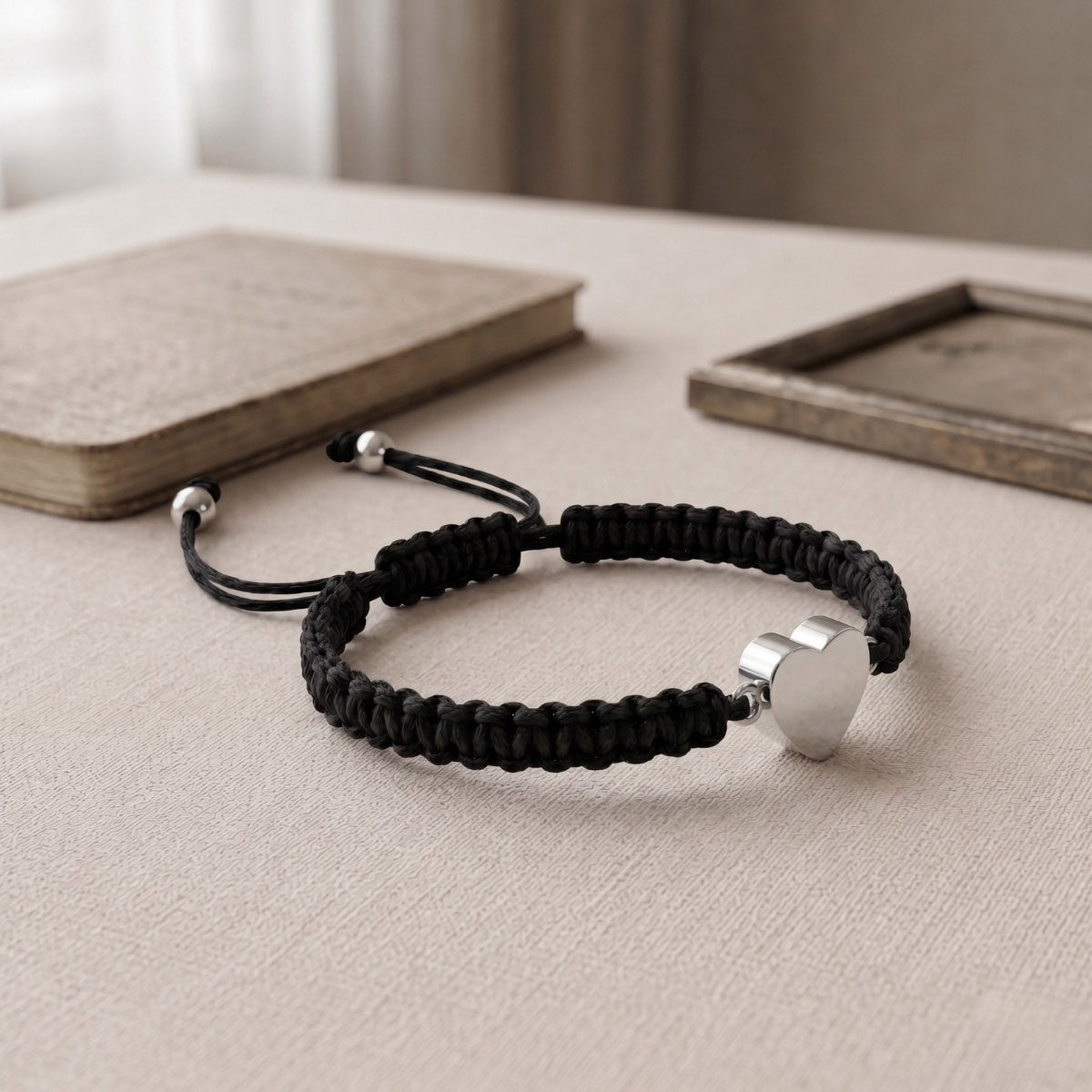 Bracelet cœur relié avec pendentif cœur argenté présenté dans une ambiance intérieure élégante et minimaliste