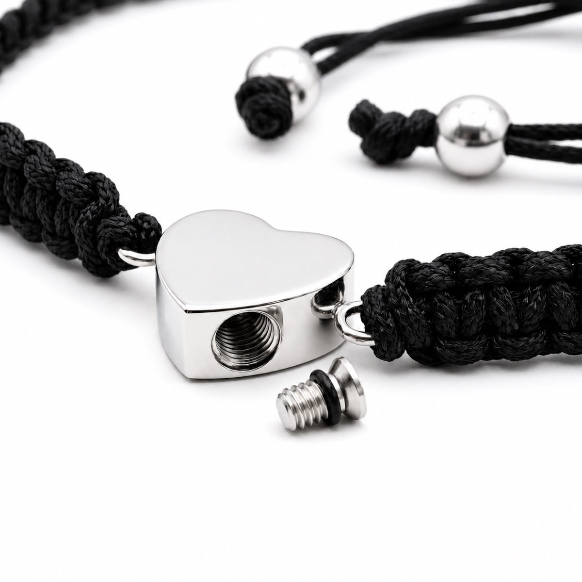 Détail du pendentif cœur argenté en acier inoxydable avec ouverture sécurisée du bracelet cœur relié