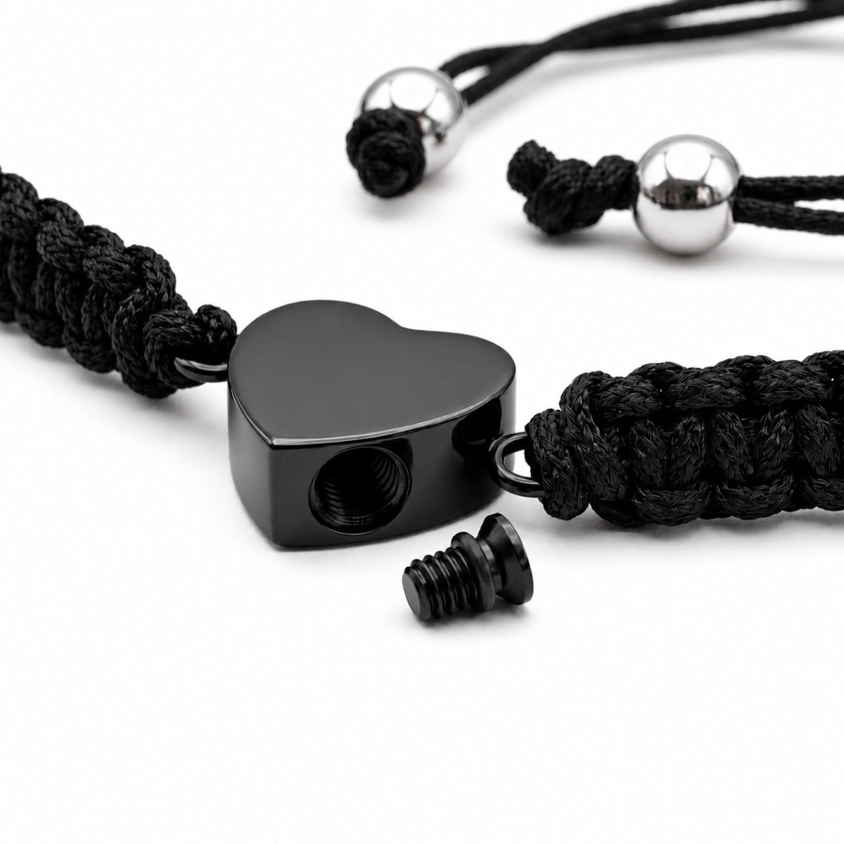 Détail du pendentif cœur noir en acier inoxydable avec ouverture sécurisée du bracelet cœur relié