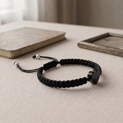 Bracelet cœur relié avec pendentif cœur noir présenté dans une ambiance intérieure élégante et minimaliste