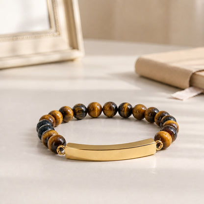 Bracelet pierre du souvenir marron metal-jaune avec perles effet pierre marron et barre présenté dans une ambiance intérieure raffinée