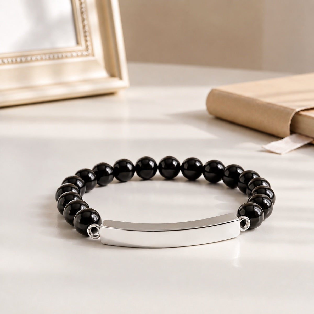 Bracelet pierre du souvenir noir metal-gris avec perles noires et barre présenté dans une ambiance intérieure raffinée