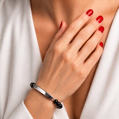 Bracelet pierre du souvenir noir metal-gris avec barre porté au poignet dans un style élégant et discret