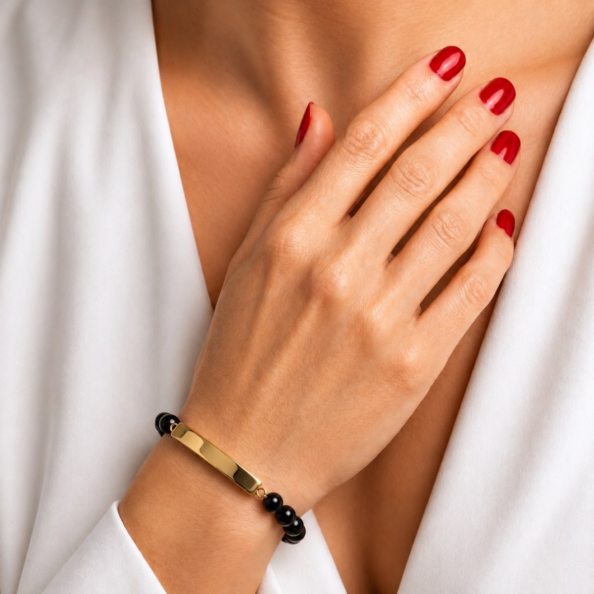 Bracelet pierre du souvenir noir metal-jaune avec barre porté au poignet dans un style élégant et discret