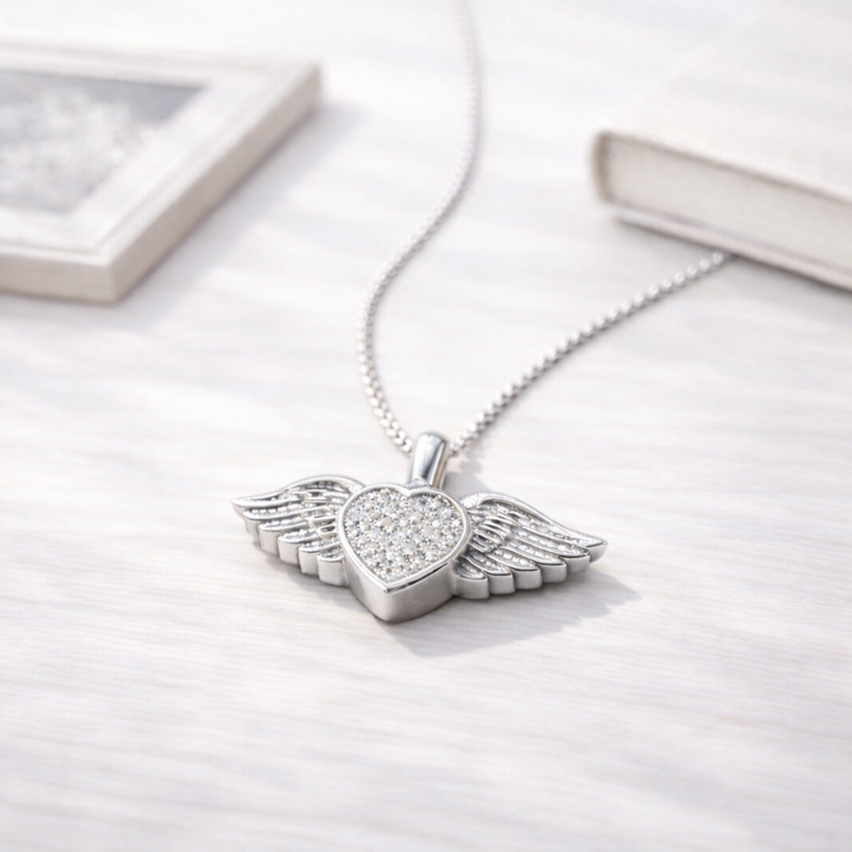 Collier cœur ailé en acier inoxydable argenté dans une ambiance élégante et minimaliste