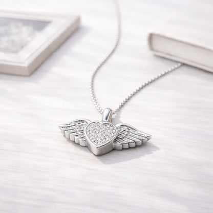 Collier cœur ailé en acier inoxydable argenté dans une ambiance élégante et minimaliste