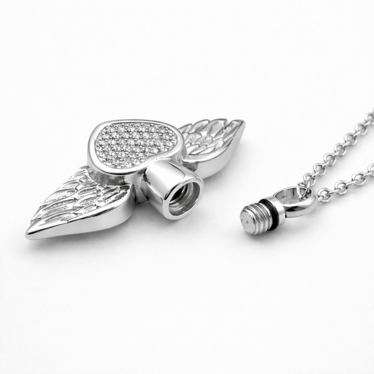 Détail du compartiment sécurisé du collier cœur ailé en acier inoxydable argenté