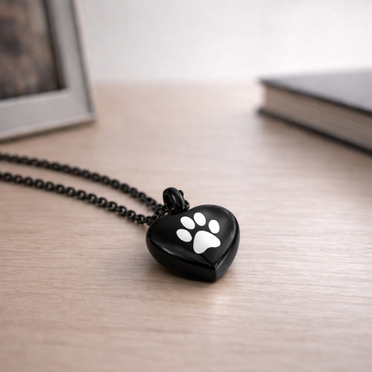 Collier cœur empreinte en acier inoxydable noir dans une ambiance élégante et minimaliste