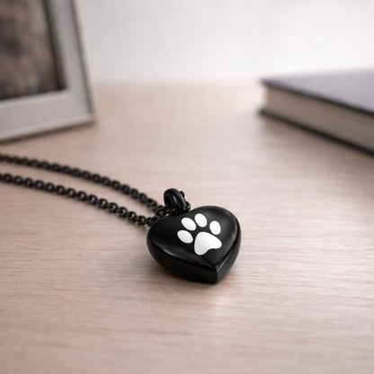 Collier cœur empreinte en acier inoxydable noir dans une ambiance élégante et minimaliste