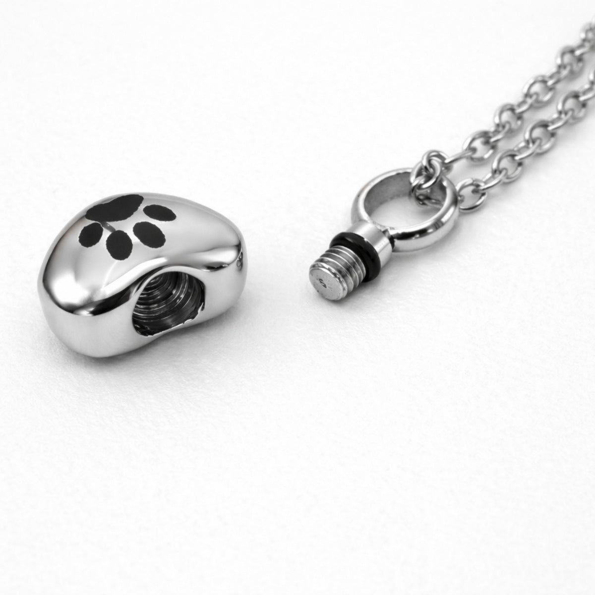 Détail du compartiment sécurisé du collier cœur empreinte en acier inoxydable argenté