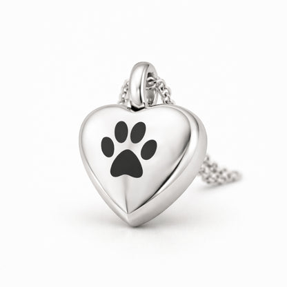 Vue 3/4 du collier cœur empreinte urne en acier inoxydable argenté mettant en valeur son relief et son compartiment intégré