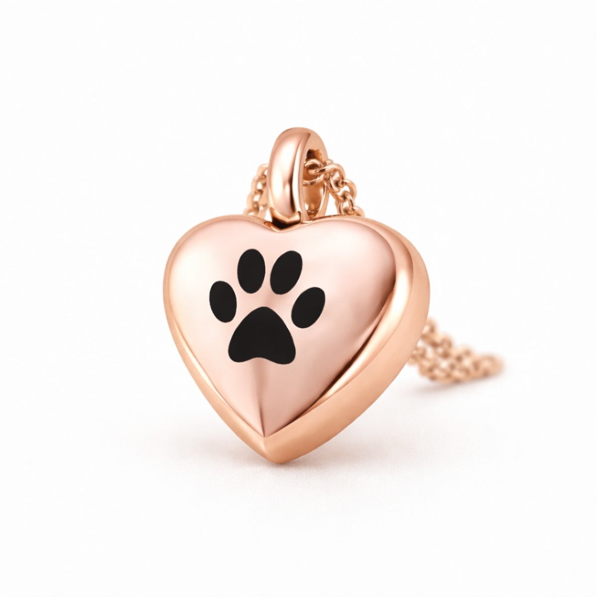 Vue 3/4 du collier cœur empreinte urne en acier inoxydable rose mettant en valeur son relief et son compartiment intégré