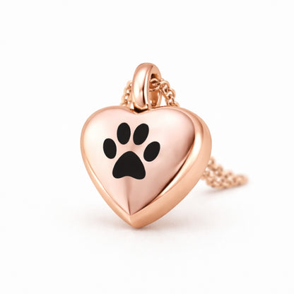 Vue 3/4 du collier cœur empreinte urne en acier inoxydable rose mettant en valeur son relief et son compartiment intégré