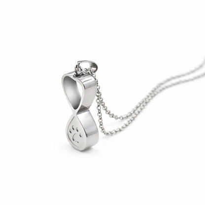 Vue 3/4 du collier empreinte éternelle urne en acier inoxydable argenté mettant en valeur son symbole infini et son compartiment intégré