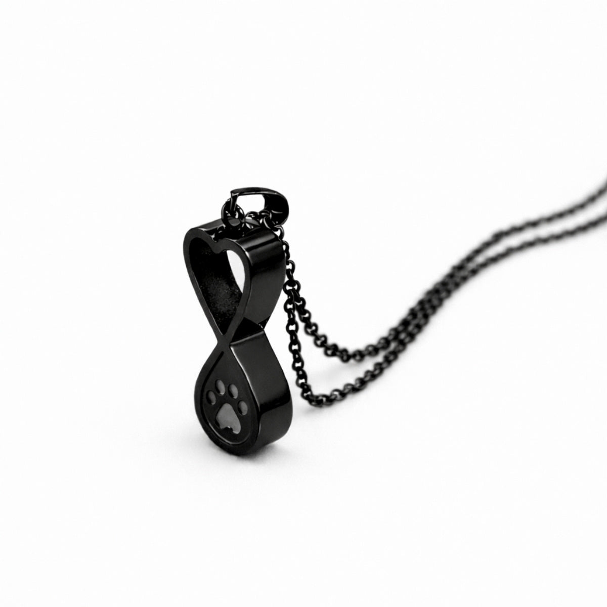 Vue 3/4 du collier empreinte éternelle urne en acier inoxydable noir mettant en valeur son symbole infini et son compartiment intégré