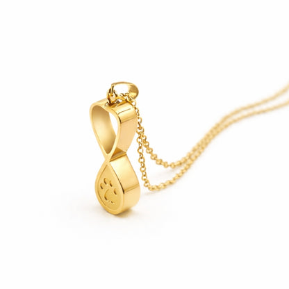 Vue 3/4 du collier empreinte éternelle urne en acier inoxydable doré mettant en valeur son symbole infini et son compartiment intégré