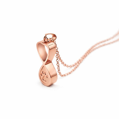 Vue 3/4 du collier empreinte éternelle urne en acier inoxydable rose mettant en valeur son symbole infini et son compartiment intégré