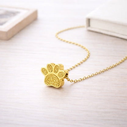 Collier empreinte fidèle en acier inoxydable doré dans une ambiance élégante et minimaliste