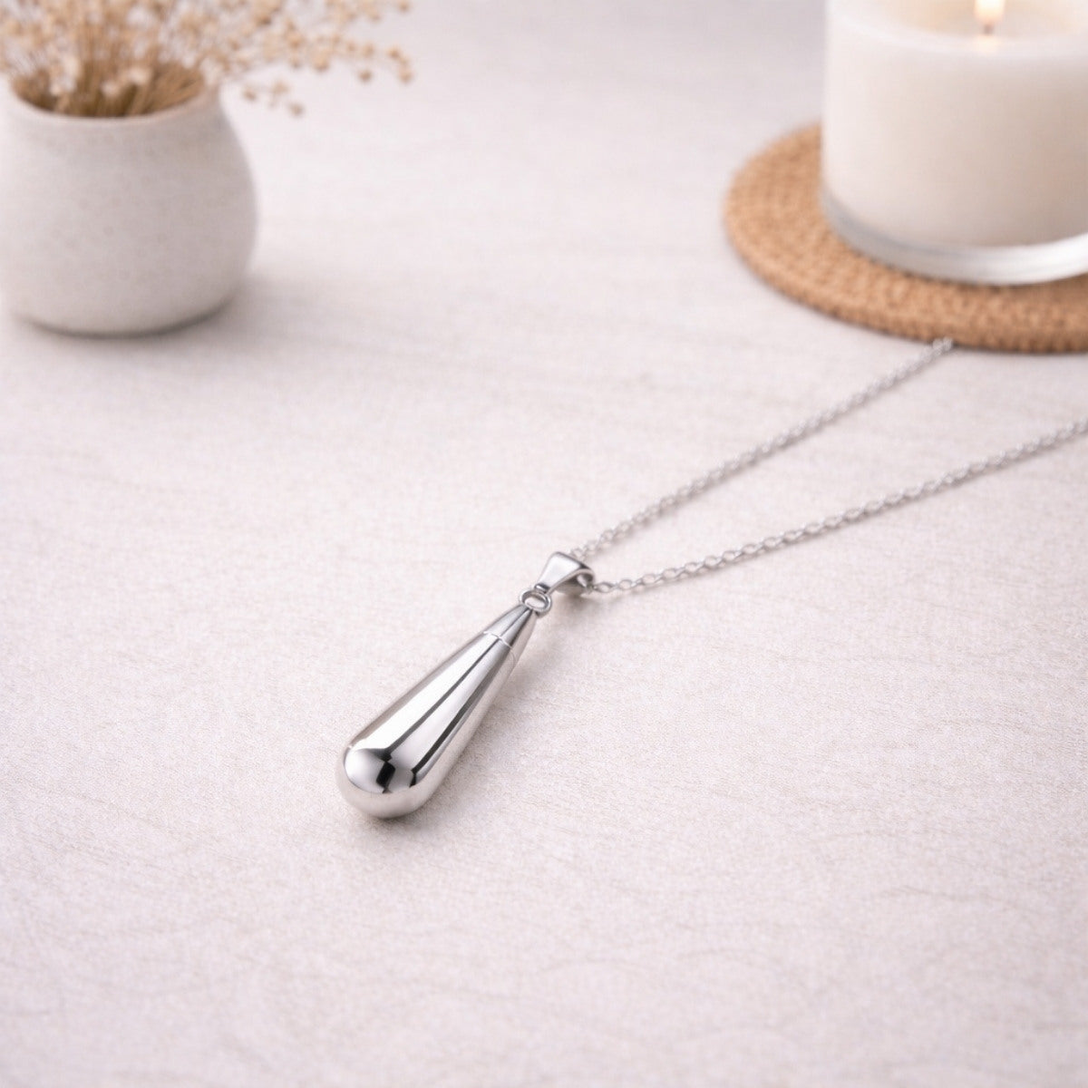Collier goutte en acier inoxydable argenté dans une ambiance élégante et minimaliste