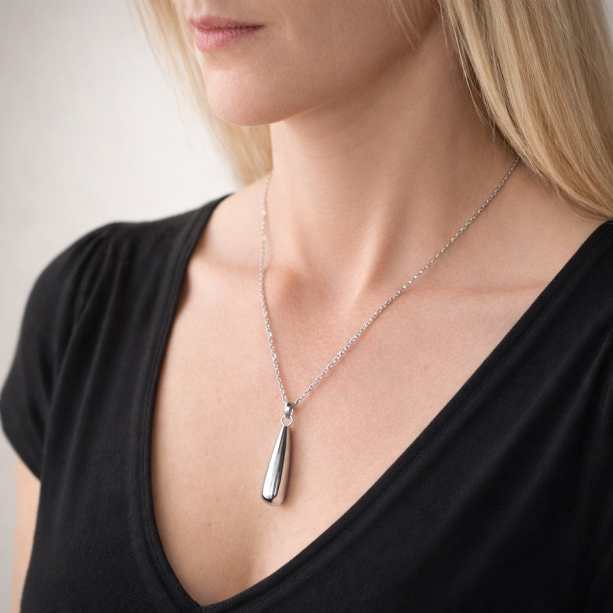 Collier goutte argenté au cou – bijou symbolique discret Mementery