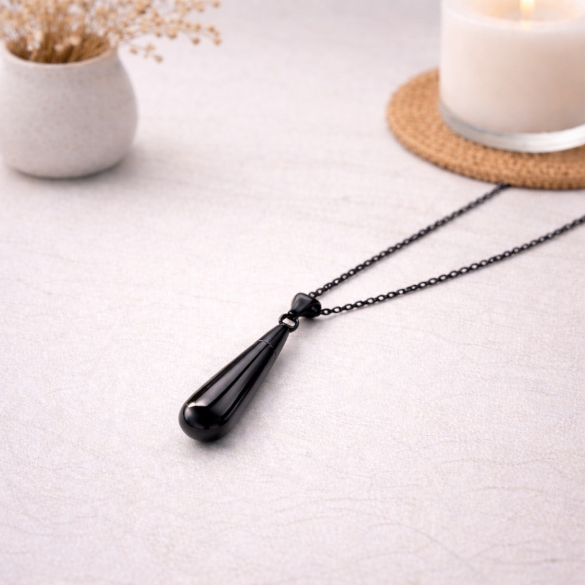 Collier goutte en acier inoxydable noir dans une ambiance élégante et minimaliste