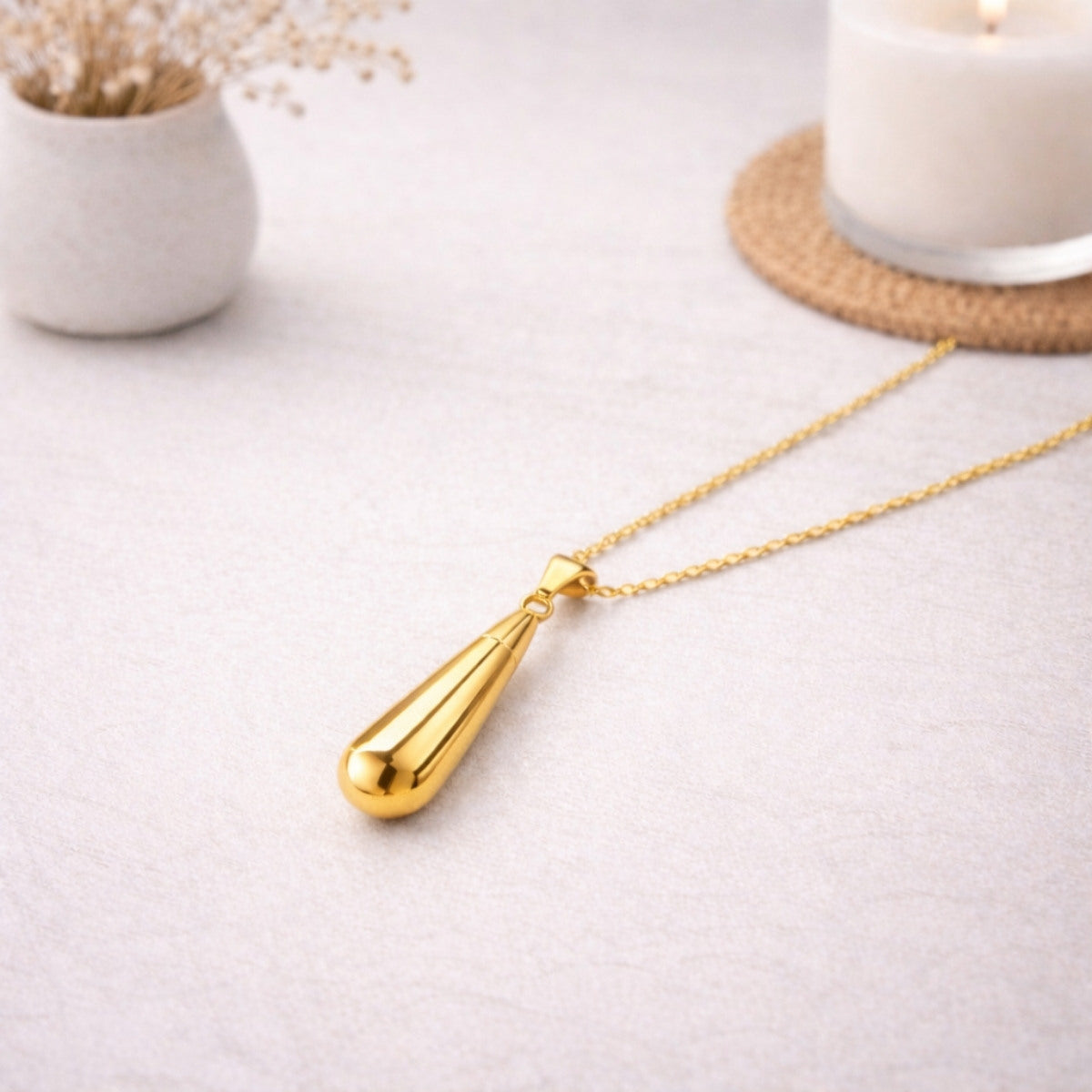 Collier goutte en acier inoxydable doré dans une ambiance élégante et minimaliste