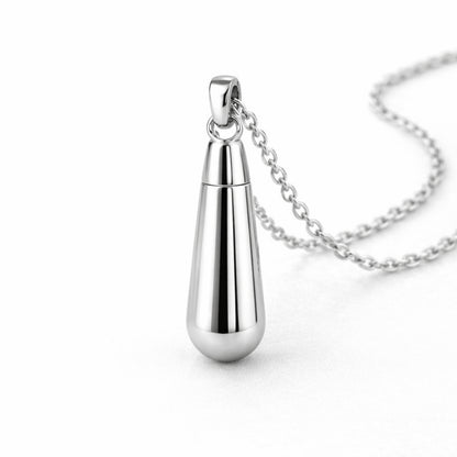 Vue 3/4 du collier goutte urne en acier inoxydable argenté mettant en valeur sa silhouette en goutte et son compartiment intégré