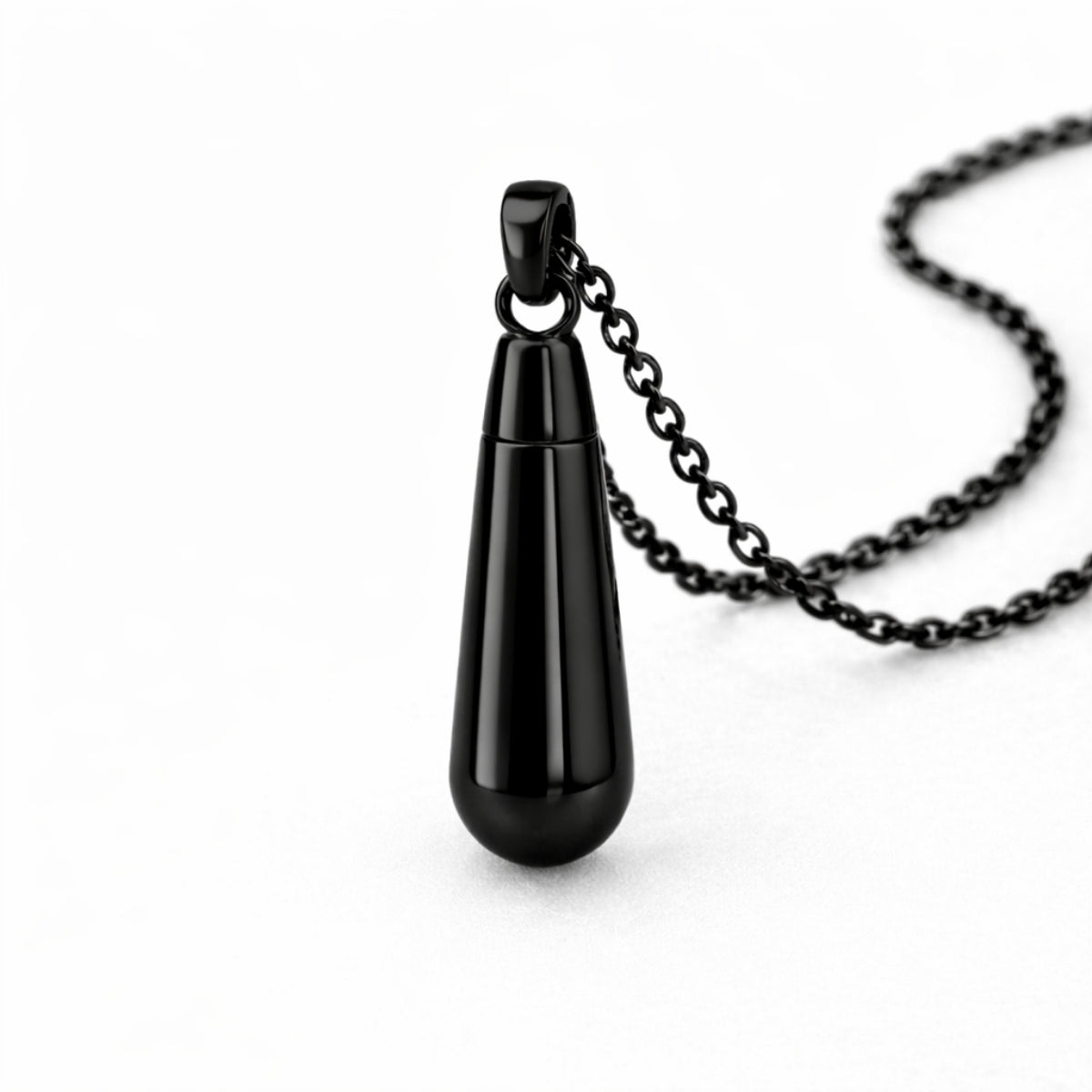 Vue 3/4 du collier goutte urne en acier inoxydable noir mettant en valeur sa silhouette en goutte et son compartiment intégré