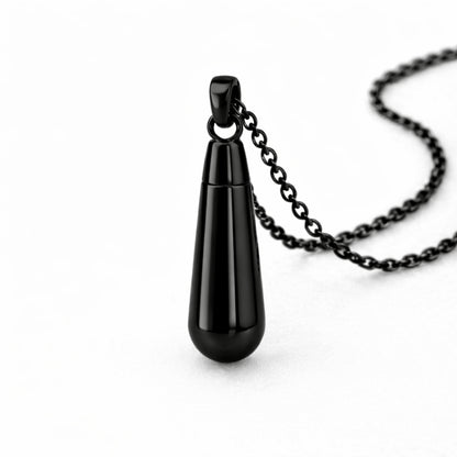 Vue 3/4 du collier goutte urne en acier inoxydable noir mettant en valeur sa silhouette en goutte et son compartiment intégré