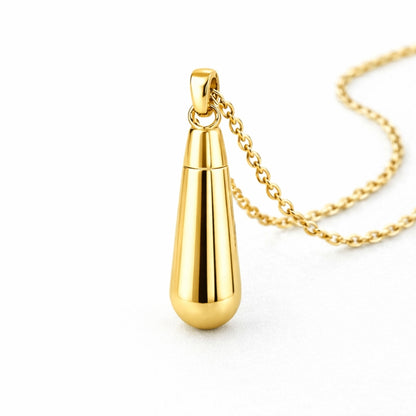 Vue 3/4 du collier goutte urne en acier inoxydable doré mettant en valeur sa silhouette en goutte et son compartiment intégré