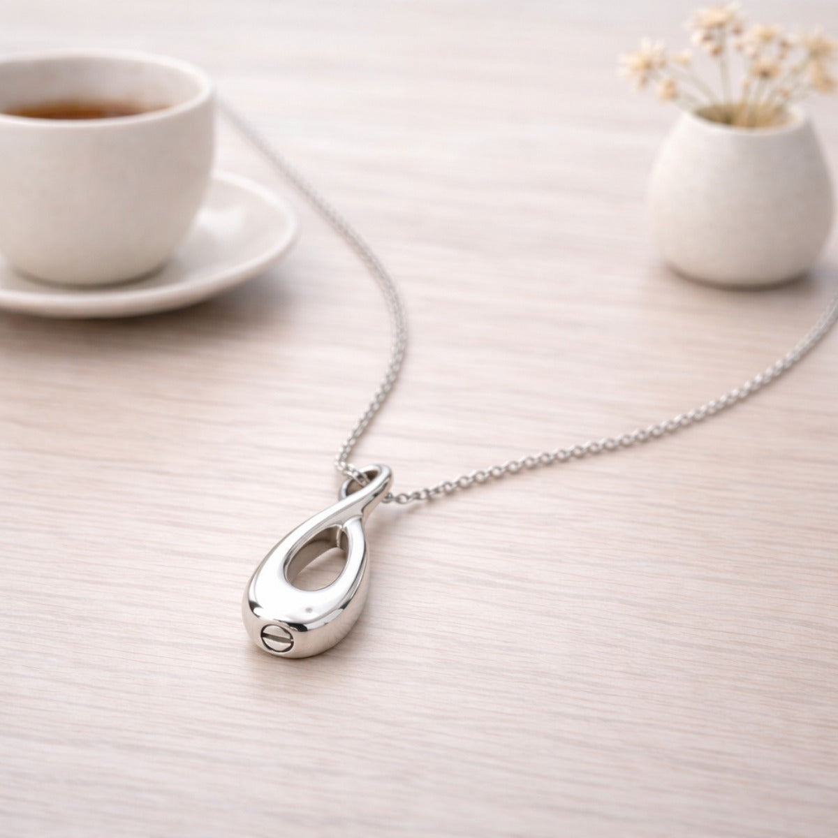 Collier Lien Éternel urne argenté présenté dans une ambiance claire et élégante