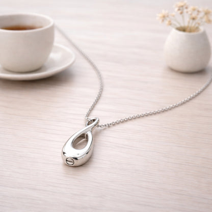Collier Lien Éternel urne argenté présenté dans une ambiance claire et élégante