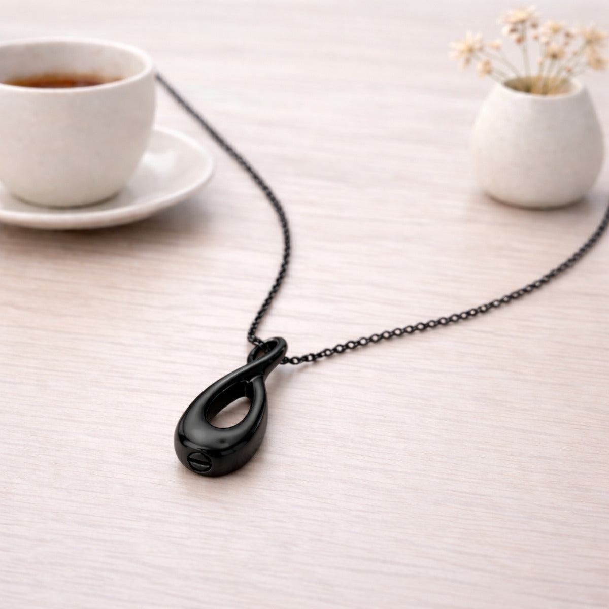 Collier Lien Éternel urne noir présenté dans une ambiance claire et élégante