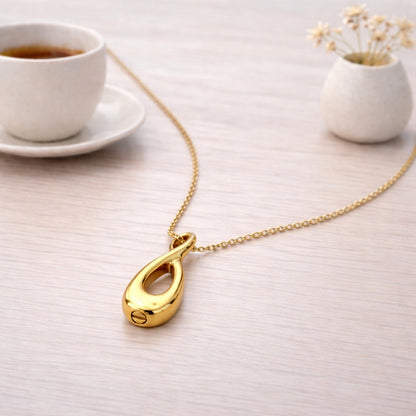 Collier Lien Éternel urne doré présenté dans une ambiance claire et élégante