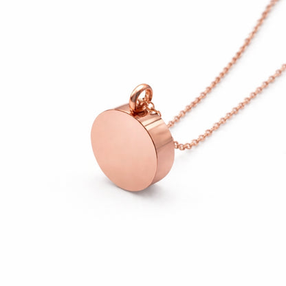 Vue 3/4 du pendentif cercle éternel urne en acier inoxydable rose mettant en valeur sa silhouette ronde et son compartiment intégré