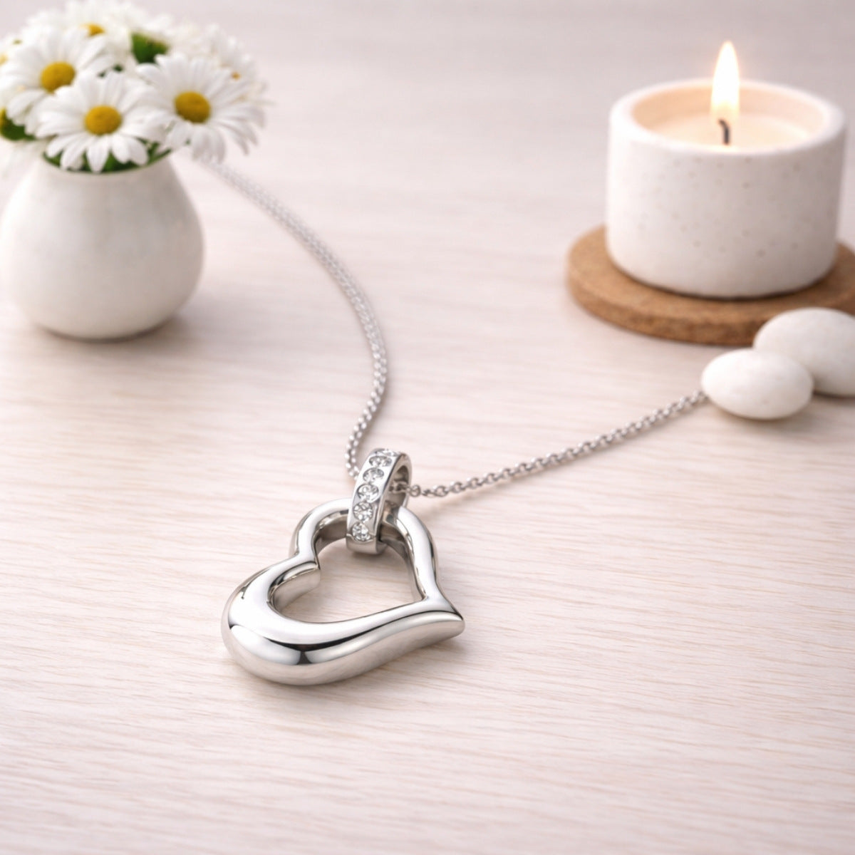 Pendentif cœur éternel urne argenté présenté dans une ambiance claire et élégante