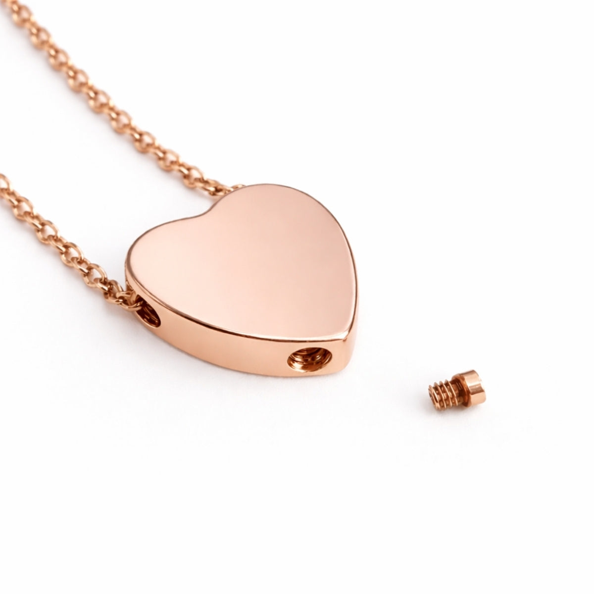 Détail de la vis et du compartiment sécurisé du pendentif cœur urne en acier inoxydable rose