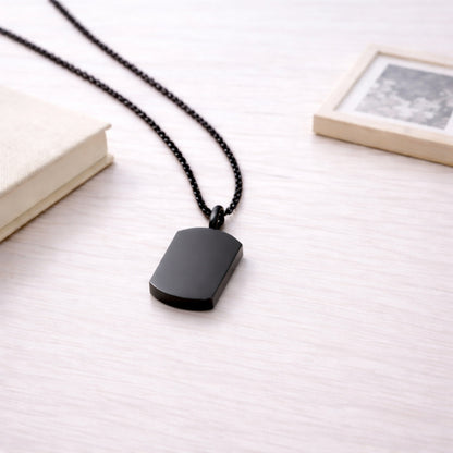 Pendentif Héritage urne noir présenté dans une ambiance claire et élégante