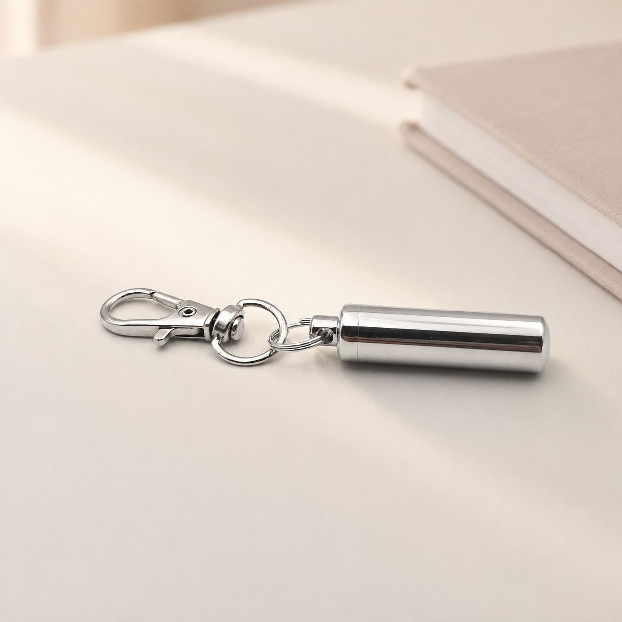 Porte-clés Capsule du Souvenir en acier inoxydable argenté dans une ambiance élégante et minimaliste