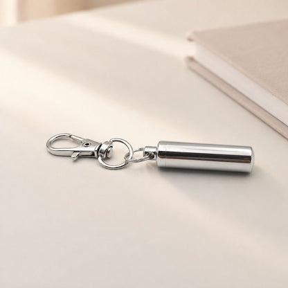 Porte-clés Capsule du Souvenir en acier inoxydable argenté dans une ambiance élégante et minimaliste