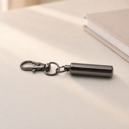 Porte-clés Capsule du Souvenir en acier inoxydable noir dans une ambiance élégante et minimaliste
