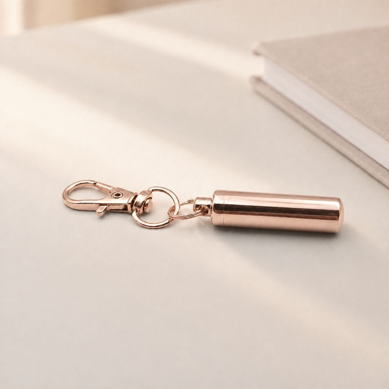 Porte-clés Capsule du Souvenir en acier inoxydable rose dans une ambiance élégante et minimaliste