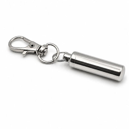 Vue 3/4 du porte-clés Capsule du Souvenir urne en acier inoxydable argenté avec mousqueton et capsule cylindrique