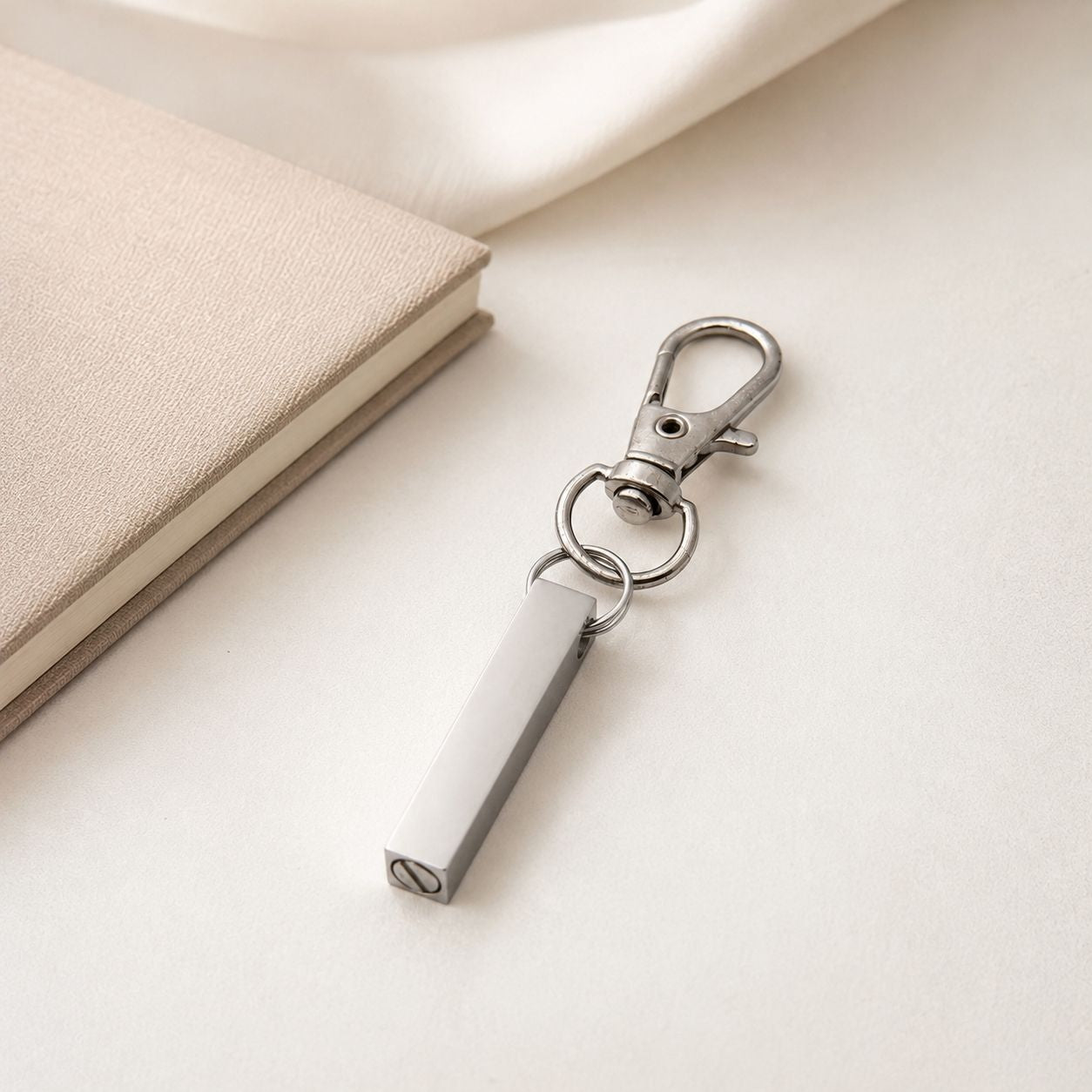 Porte-clés Écrin du Souvenir en acier inoxydable argenté dans une ambiance élégante et minimaliste
