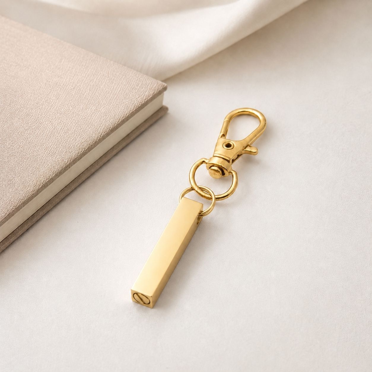 Porte-clés Écrin du Souvenir en acier inoxydable doré dans une ambiance élégante et minimaliste