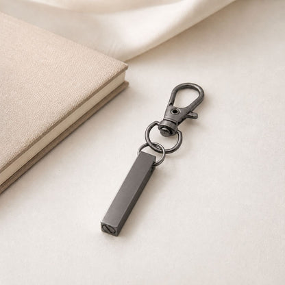 Porte-clés Écrin du Souvenir en acier inoxydable noir dans une ambiance élégante et minimaliste