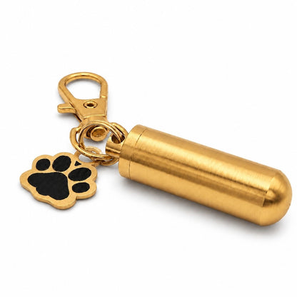 Vue 3/4 du porte-clés Empreinte du Souvenir urne en acier inoxydable doré avec pendentif patte et cylindre souvenir
